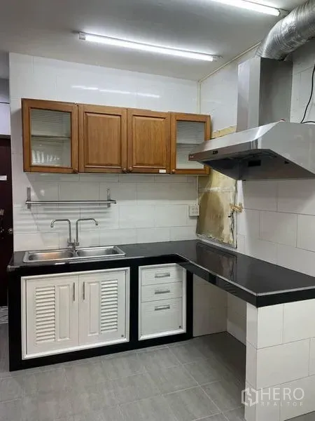 零售空间 出租在Watthana, Bangkok - 紧凑茶水间，瓷砖墙面、不锈钢水槽、油烟机与木质吊柜。