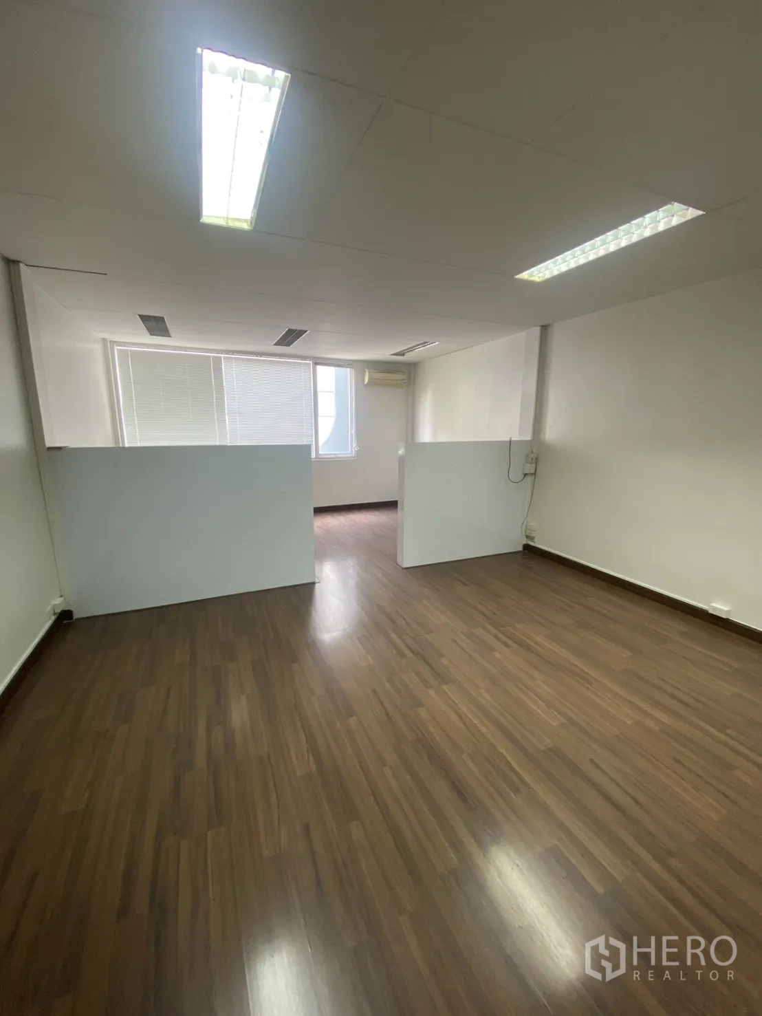 Shophouse for rent in Bang Rak, Bangkok - Open-plan office area with partitions and wood flooring under fluorescent lights.