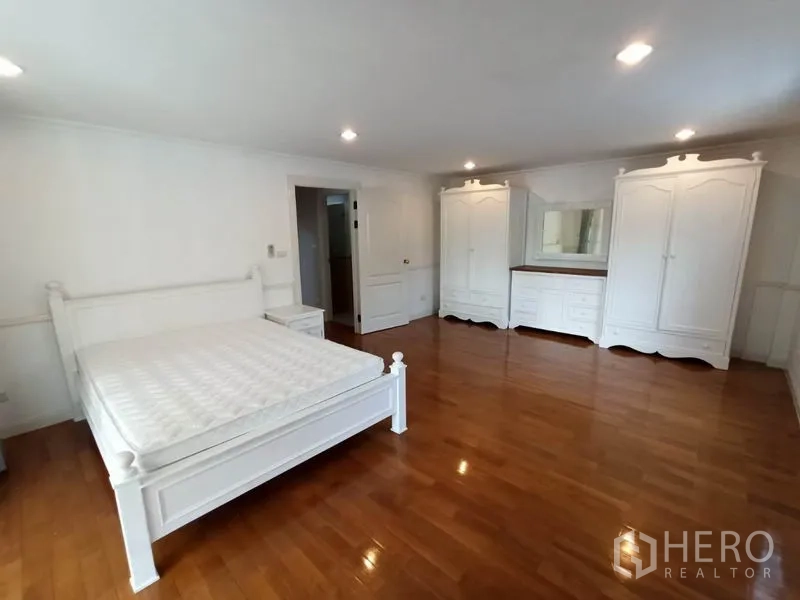 独立式住宅 出租在Mueang Samut Prakan, Samut Prakan - 宽敞主卧，木地板，白色床与整套衣柜。