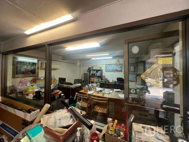 店屋 出租 - 玻璃隔断的办公室，荧光灯照明与办公桌。