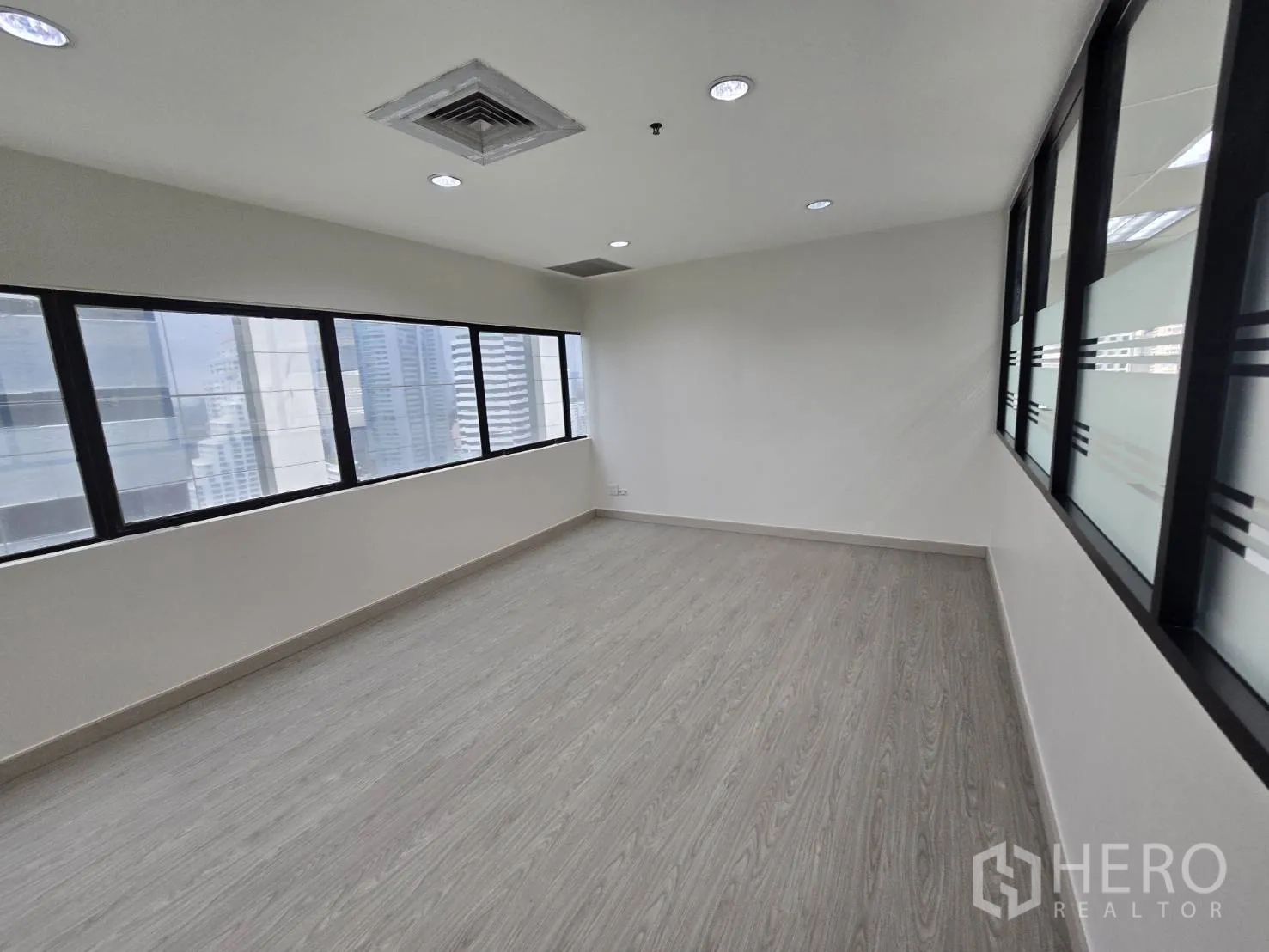 Office Space for rent in Khlong Toei, Bangkok - Private room with windows and interior glass partition offering city views.