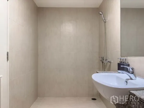 Condominium for sale in Watthana, Bangkok - Modern tiled bathroom with wall-mounted shower and countertop sink in a Thonglor condo.