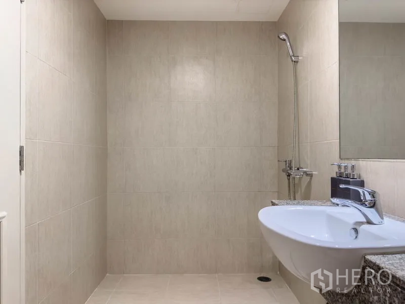 Condominium for sale in Watthana, Bangkok - Modern tiled bathroom with wall-mounted shower and countertop sink in a Thonglor condo.