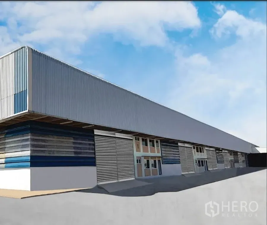 คลังสินค้า ให้เช่าในSi Maha Phot, Prachin Buri - ด้านหน้าโกดังผนังเมทัลชีทยาว พร้อมประตูม้วนหลายบานและทางวิ่งรถบรรทุก