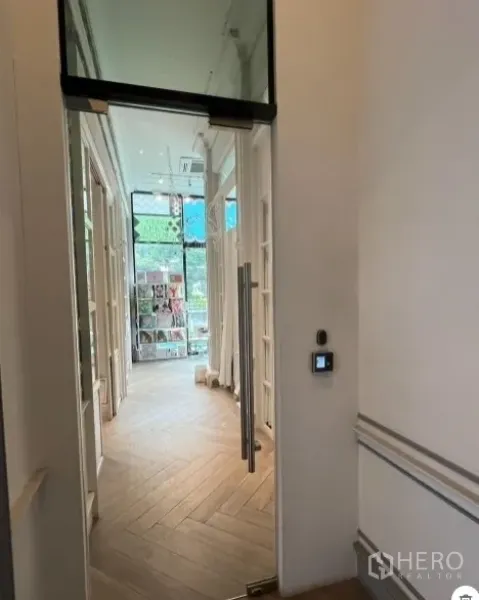 พื้นที่ขายปลีก ให้เช่าในWatthana, Bangkok - ทางเดินสว่างพื้นไม้ลายก้างปลา ประตูกระจก และมุมโชว์สินค้าเห็นวิวถนน