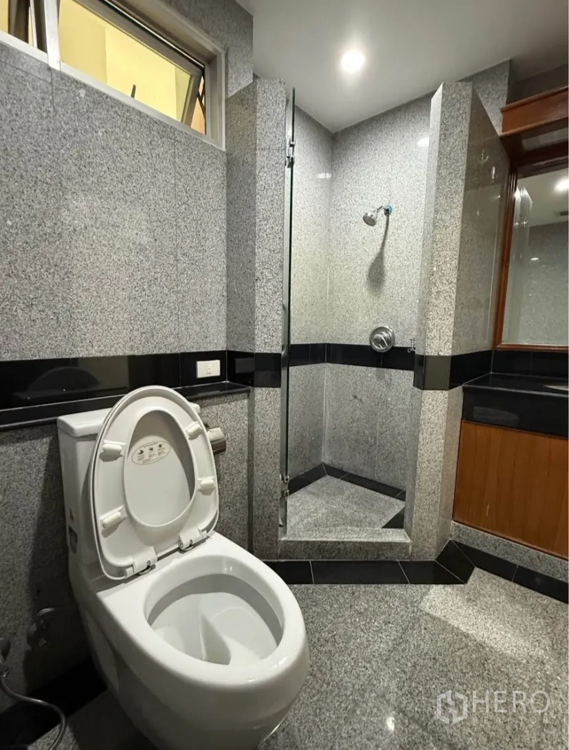 คอนโด for rent in Pathum Wan, Bangkok - ห้องน้ำพร้อมตู้กระจกอาบน้ำ ผนังแกรนิต โถสุขภัณฑ์ และเคาน์เตอร์อ่างล้างหน้า