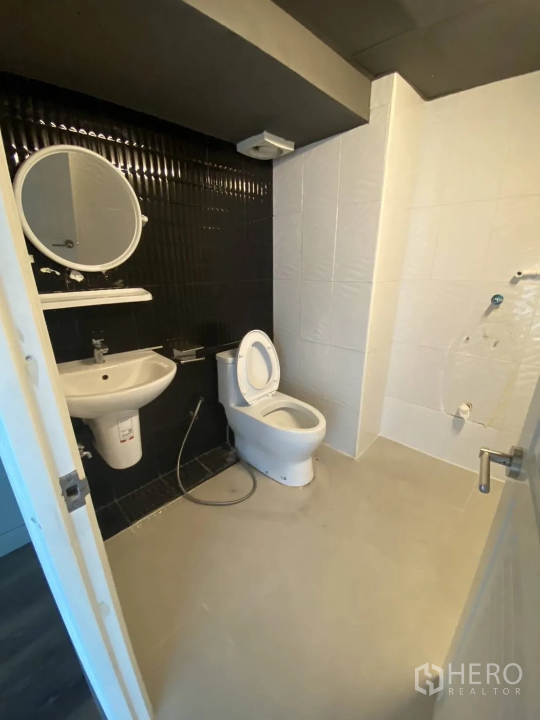 零售空间 出租在Huai Khwang, Bangkok - 整洁卫生间，坐便器、洗手盆和黑白对比瓷砖。