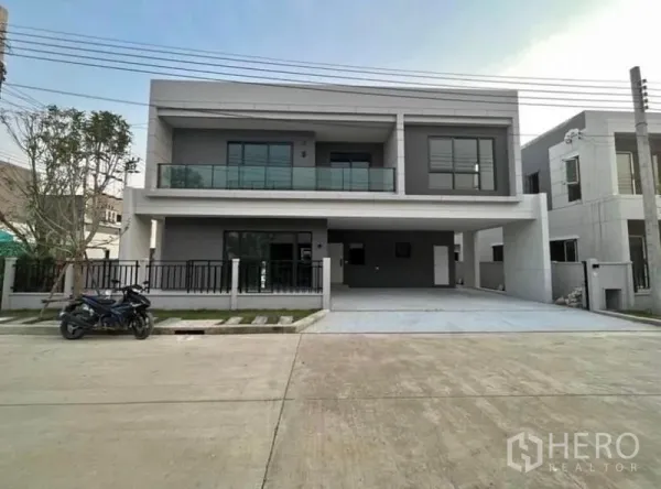 Detached House for rent in Bang Phli, Samut Prakan - Modern two-storey detached house in Bang Phli with glass balcony, gated fence and a wide double carport.