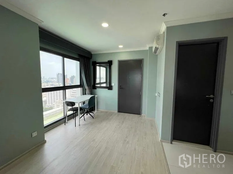 Condominium for sale in Ratchathewi, Bangkok - Corner unit with panoramic windows, study table and expansive Bangkok city view.