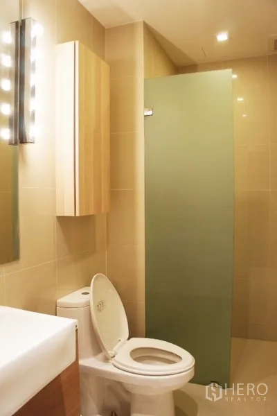 คอนโด ให้เช่าในPhaya Thai, Bangkok - ห้องน้ำโทนครีม พร้อมโถสุขภัณฑ์ อ่างล้างหน้า และฉากกั้นอาบน้ำกระจกฝ้า