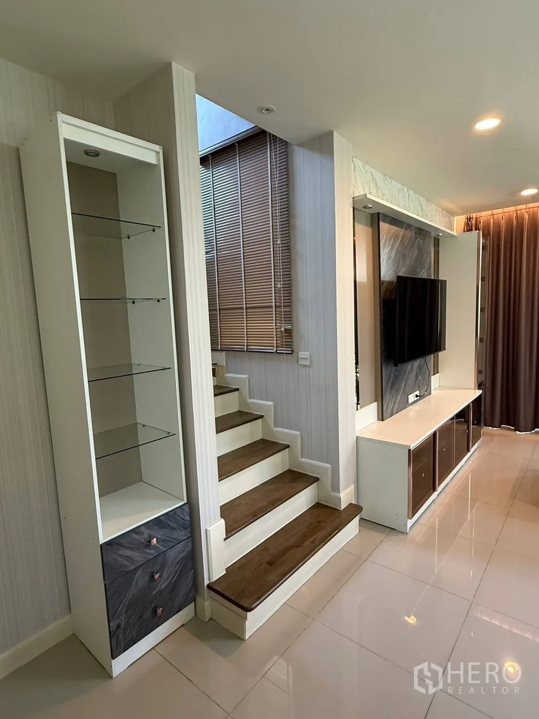 Detached House for rent in Prawet, Bangkok - Wood-trim staircase with built-in display shelving and a tall window.
