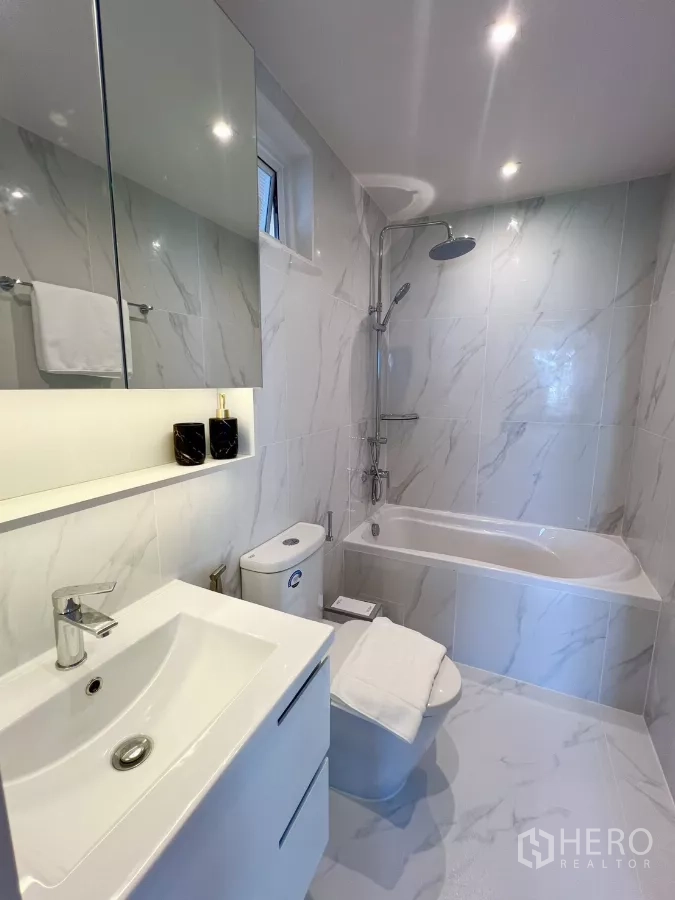 公寓 出售在Yan Nawa, Bangkok - 浴室配浴缸、盥洗台与大理石纹墙砖。