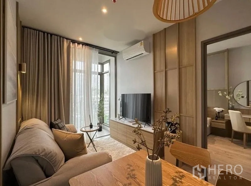 公寓 出租或出售在Watthana, Bangkok - 客厅面向阳台，电视柜、空调及通往卧室的门一览无余。