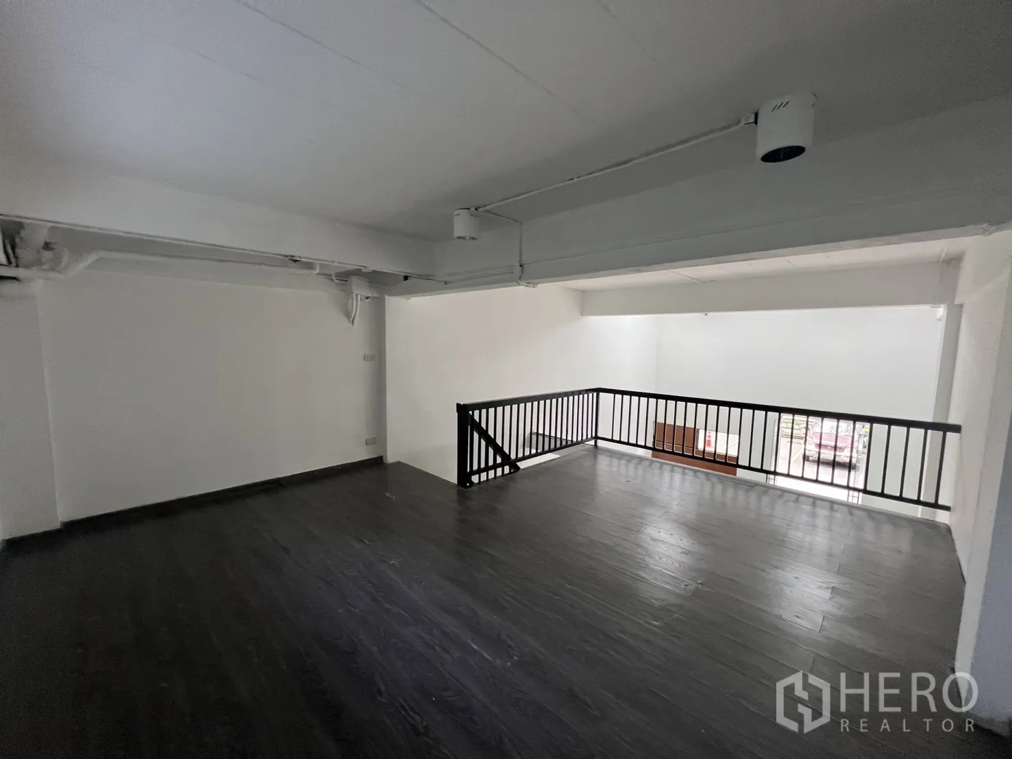 零售空间 出租在Watthana, Bangkok - 宽敞夹层平台，通透栏杆与白色墙面，灵活布局。