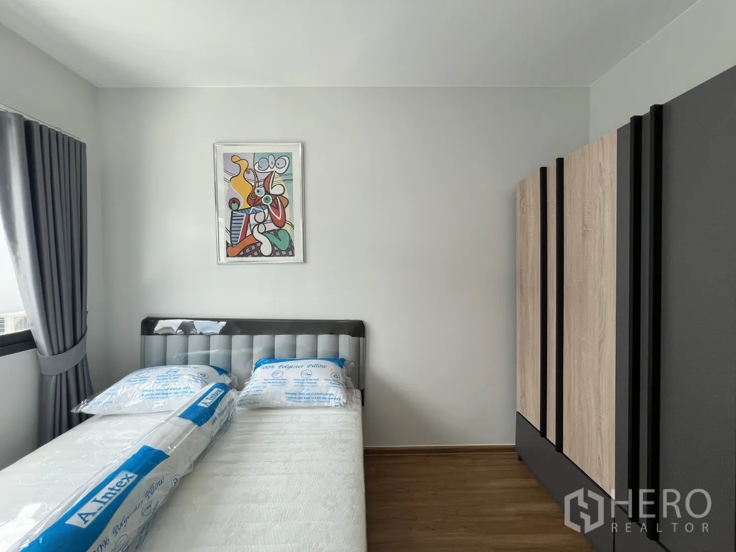 Townhouse for rent in Bang Phli, Samut Prakan - Sunlit bedroom with grey curtains, bed, and a large wardrobe.
