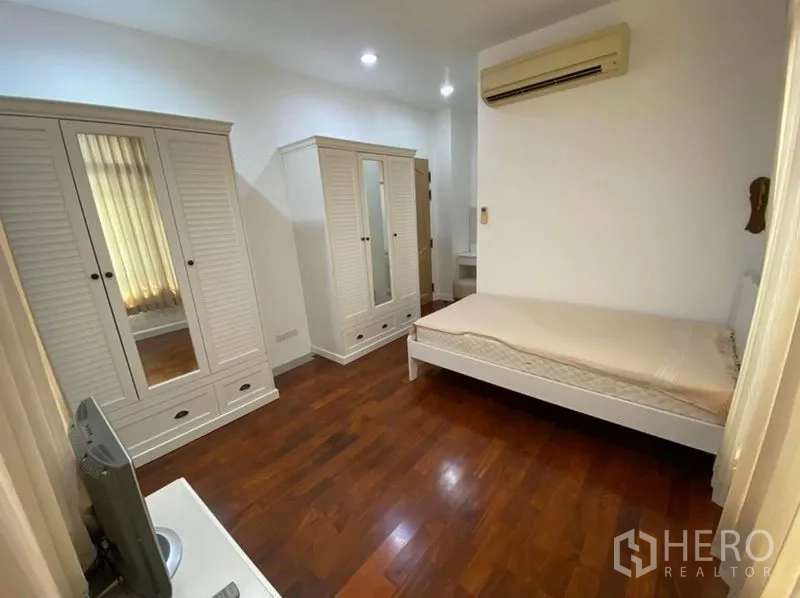 Detached House for rent in Bang Phli, Samut Prakan - Bright bedroom with wooden floors, white wardrobes and wall air conditioner.