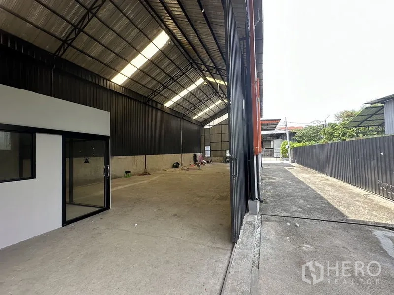 คลังสินค้า ให้เช่าในLat Phrao, Bangkok - ช่องเปิดกว้างของโกดังมองออกสู่ลาน พร้อมหลังคาสูงและช่องระบายอากาศ