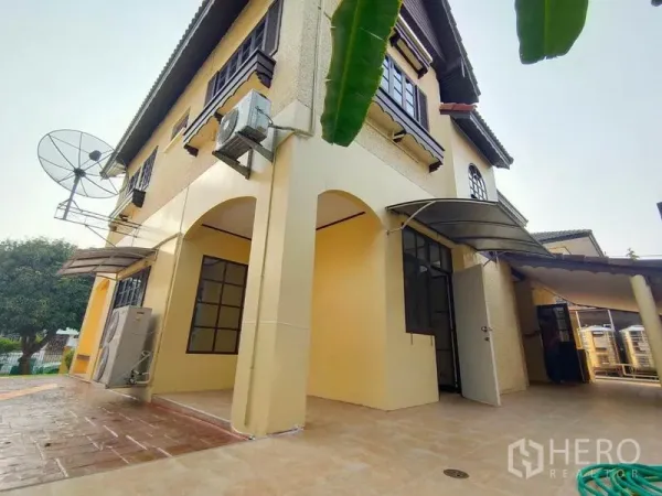 Detached House for rent - Side view of the house showing arched patio and awnings over windows and doors.