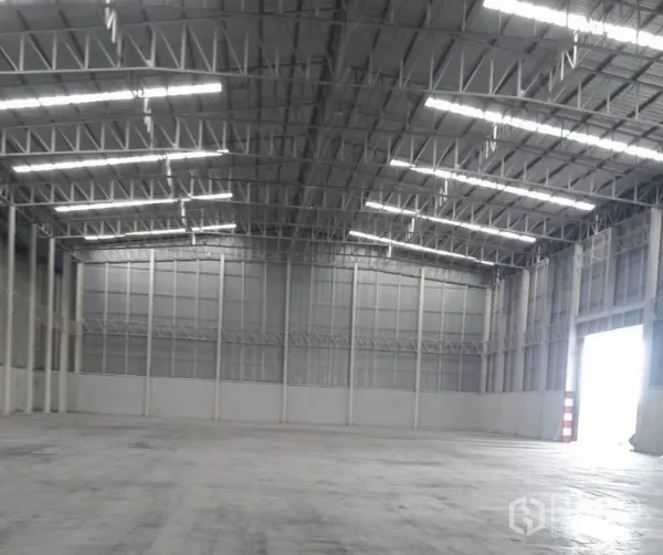 Warehouse for rent in Phra Nakhon Si Ayutthaya - High-clearance warehouse interior with steel truss roof, skylights, and polished concrete floor.