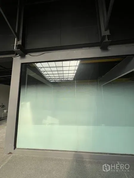 Retail Space for rent in Watthana, Bangkok - Exterior close-up of expansive frosted glass window and metal structure of the unit.