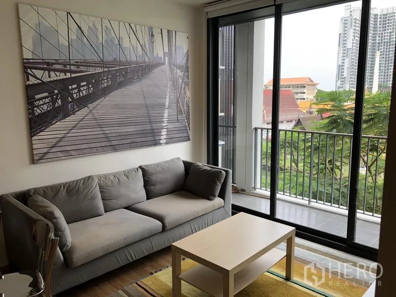 公寓 出租在Watthana, Bangkok - 沙发角落旁大型推拉门，通往可眺望绿景的阳台。