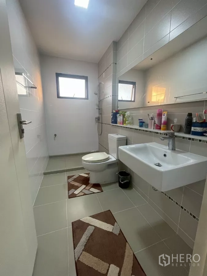 Detached House for sale in Bang Phli, Samut Prakan - Modern bathroom with walk-in shower, toilet and wall-mounted basin in grey tiles.