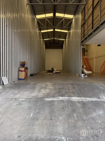 Warehouse for rent in Suan Luang, Bangkok - High-ceiling warehouse bay with steel cladding, skylights and a smooth concrete floor.
