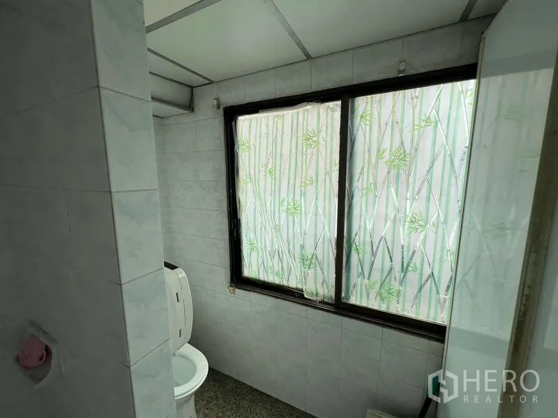 Office Space for rent - Simple tiled restroom with frosted window and natural light.