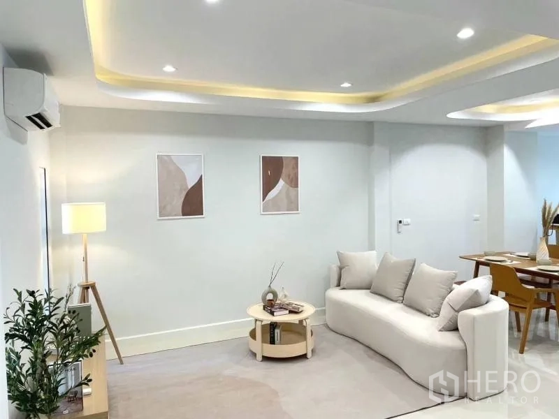 联排别墅 出售在Khlong Toei, Bangkok - 客厅设有灯带与空调，现代沙发并可望见餐区。