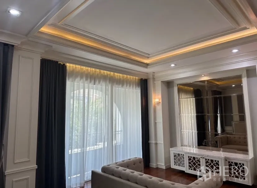บ้านเดี่ยว for rent or sale in Prawet, Bangkok - ห้องนั่งเล่นสไตล์หรู เพดานหลุมซ่อนไฟ ผ้าม่านโปร่ง และตู้คอนโซลกระจกเงา