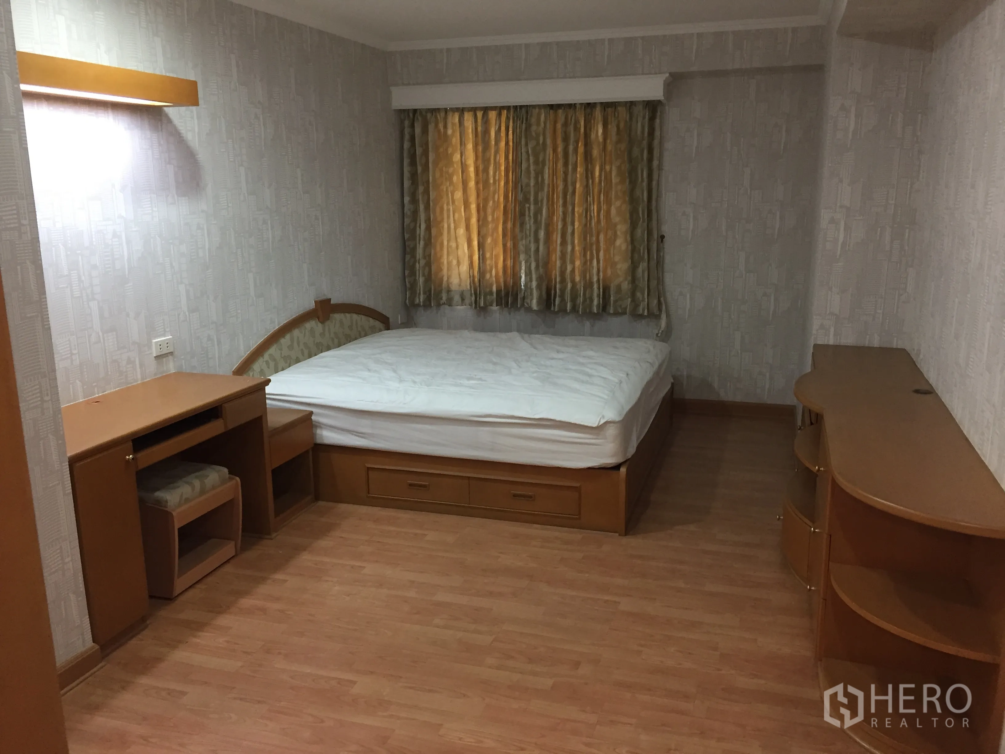 Condominium for rent in Watthana, Bangkok - Second bedroom featuring a bed with storage drawers, work desk, shelving, and wood floors.