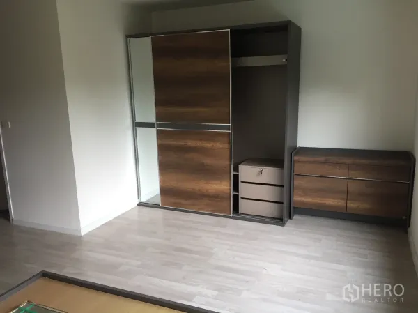 Townhouse for rent in Bang Kapi, Bangkok - Bedroom with light wood flooring and built-in wardrobe and dresser.