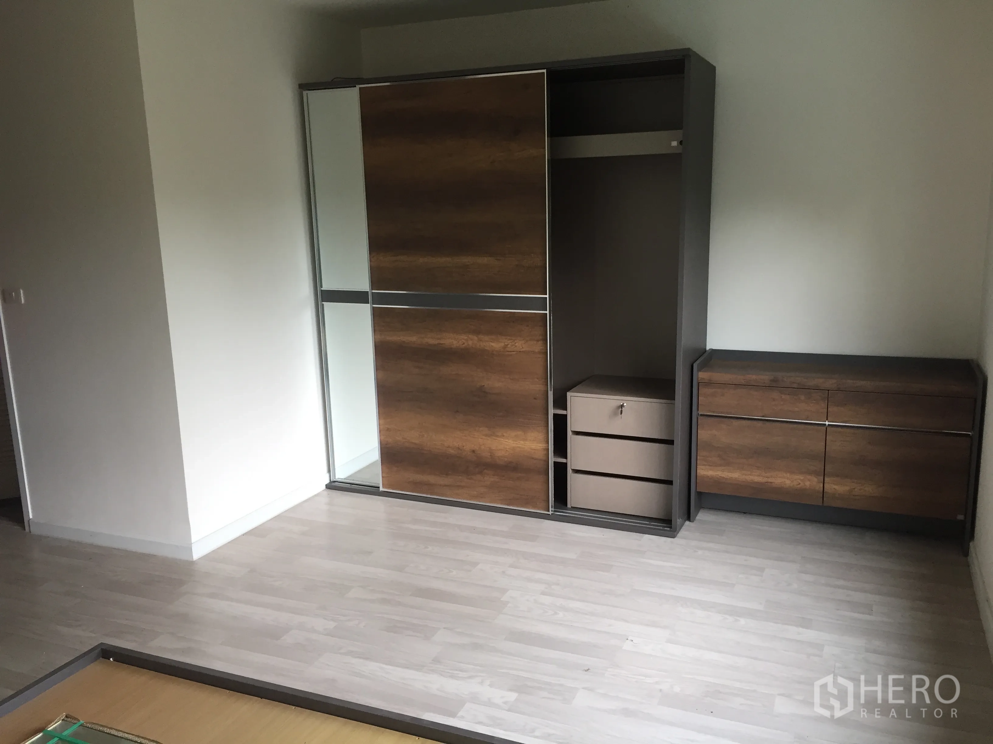 Townhouse for rent in Bang Kapi, Bangkok - Bedroom with light wood flooring and built-in wardrobe and dresser.