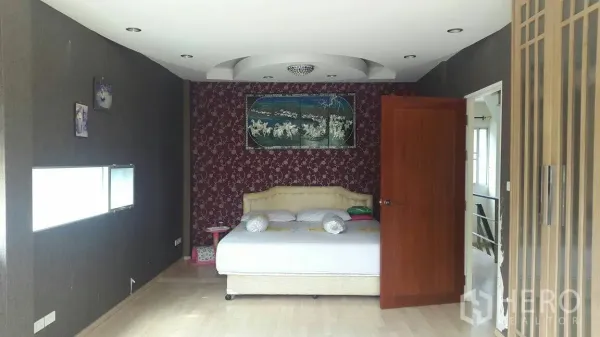 联排别墅 出租在Suan Luang, Bangkok - 主卧带特色背景墙与造型天花，连接套间卫生间。