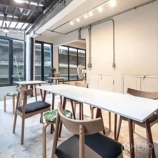 สำนักงานที่บ้าน ให้เช่าในBang Rak, Bangkok - พื้นที่ทำงานแบบโอเพ่นสเปซ โต๊ะประชุมสีขาว เก้าอี้ไม้ และหน้าต่างบานใหญ่