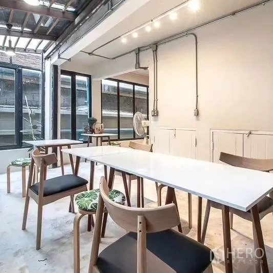 สำนักงานที่บ้าน ให้เช่าในBang Rak, Bangkok - พื้นที่ทำงานแบบโอเพ่นสเปซ โต๊ะประชุมสีขาว เก้าอี้ไม้ และหน้าต่างบานใหญ่