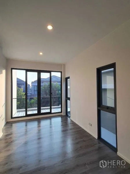 Detached House for sale in Prawet, Bangkok - Upper-floor room with balcony doors and community view.