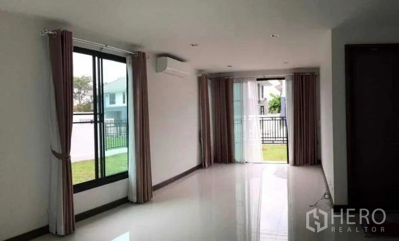 Detached House for rent or sale in Thanyaburi, Pathum Thani - Living area opening to the garden through large sliding glass doors.