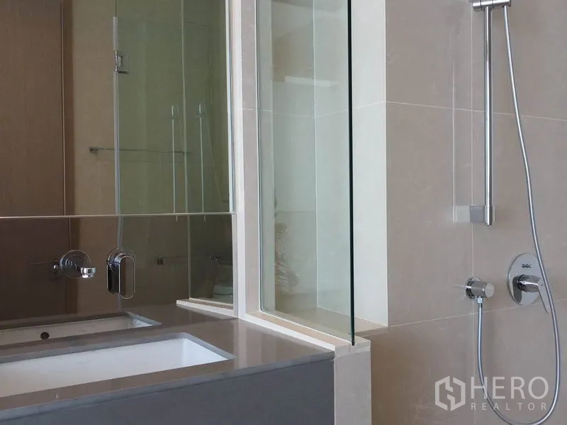 公寓 出租在Khlong Toei, Bangkok - 现代浴室，玻璃淋浴间、手持花洒与长台盆柜