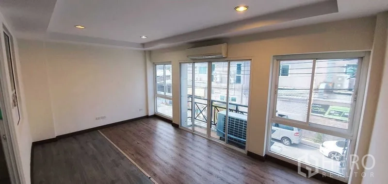 带办公室的家 出租在Prawet, Bangkok - 采光充足的客厅或办公区，木地板，空调，带阳台与多扇窗。