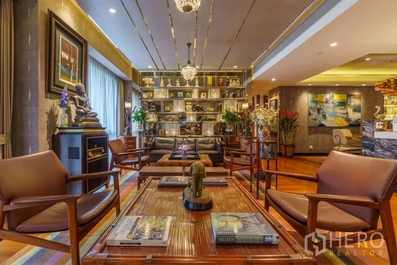 Condominium for sale in Yan Nawa, Bangkok - Lounge with decorative backlit shelving, chandeliers and large window drapes.