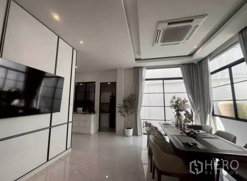 独立式住宅 出租在Lat Phrao, Bangkok - 开放式餐区，长餐桌、整面采光窗与吊顶嵌入式空调。