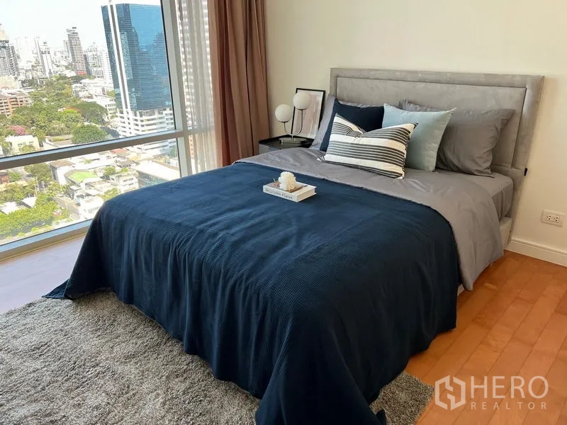 公寓 出租在Watthana, Bangkok - 次卧配大窗与城市景观，海军蓝床品的双人床。