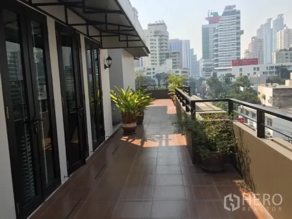 公寓 出租在Khlong Toei, Bangkok - 宽敞的私家露台，摆放盆栽，可眺望城市天际线。