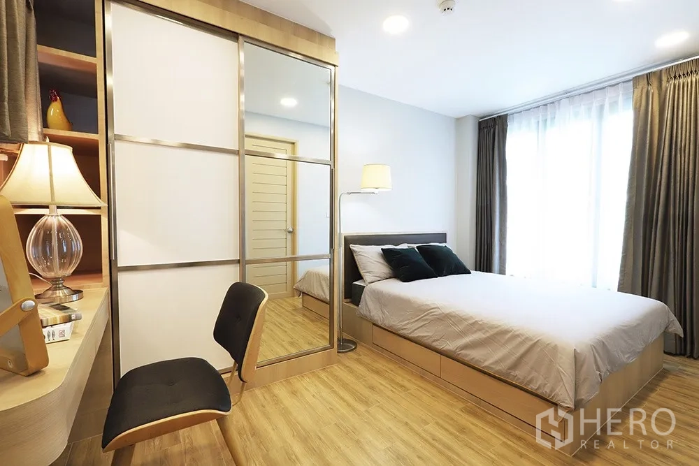 Condominium for rent in Watthana, Bangkok - Cozy bedroom with a double bed, mirrored sliding wardrobe and a work desk by the window.
