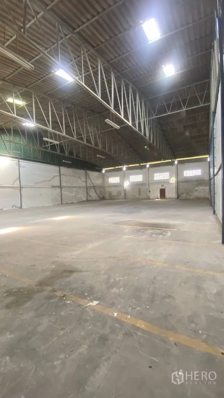 Factory for rent in Bang Phli, Samut Prakan - Warehouse floor with marked lanes beneath high ceiling and exposed trusses.