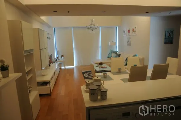 Condominium for rent or sale in Sathon, Bangkok - Open‑plan living and dining area with chandelier, blinds and light wood floors.