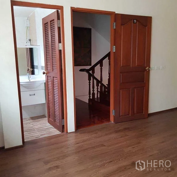 Home Office for rent in Watthana, Bangkok - Room with wood flooring, bathroom access and a wooden staircase.