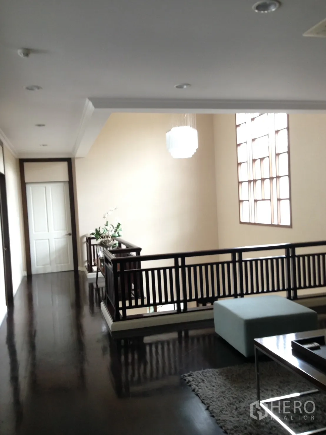 Detached House for rent or sale in Suan Luang, Bangkok - Upstairs landing with dark wood floors, railing and pendant light.