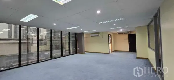 办公空间 出租 - 开放式办公室，落地窗、蓝色地毯与城市景观，曼谷CBD。